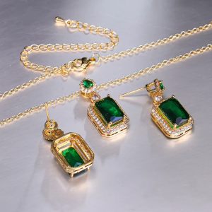 Emerald engagement ring, necklace, and earrings in gold setting