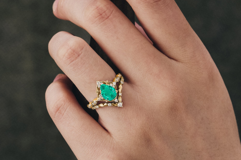 Woman wearing emerald ring symbolizing May birthstone