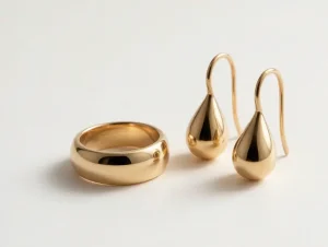 Polished 14K gold vermeil ring paired with plain gold teardrop earrings on a clean light background